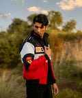 Person wearing a red, black, and white Ferrari jacket with logos outdoors