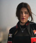 Woman wearing a black ferrari jacket with Ferrari logos against a blurred background