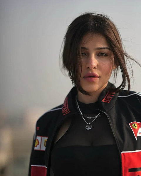 Woman wearing a black ferrari jacket with Ferrari logos against a blurred background