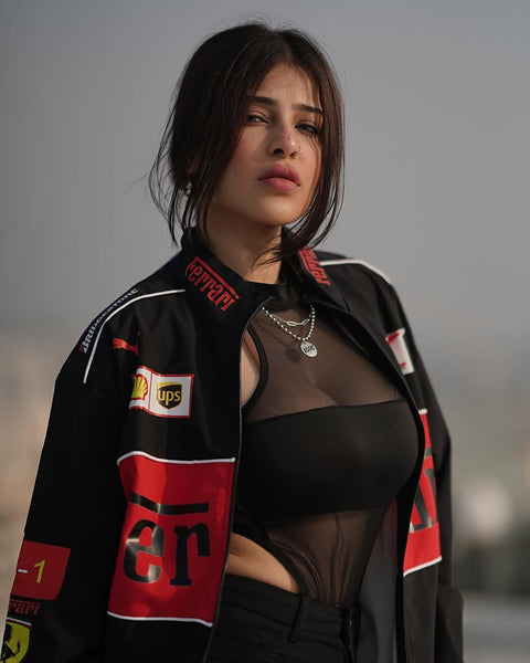 Woman wearing a black and red ferrari jacket with various logos 