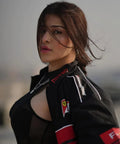 Woman wearing a Ferrari black jacket with Ferrari logos against a blurred background