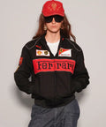 Person wearing a Women Black Ferrari Racing Jacket with red accents on a plain background