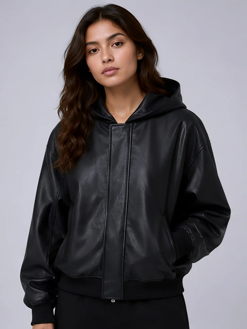 Woman wearing a Women Hooded Faux Black Leather Jacket against a gray background