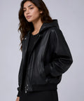 Woman wearing a black leather jacket against a gray background