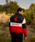 Person wearing a Ferrari jacket in an outdoor setting with trees and sky.