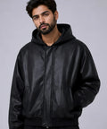 Man wearing a men-hooded-leather-jacket against a gray background
