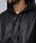 Close-up of a person wearing a black leather jacket with a hood.