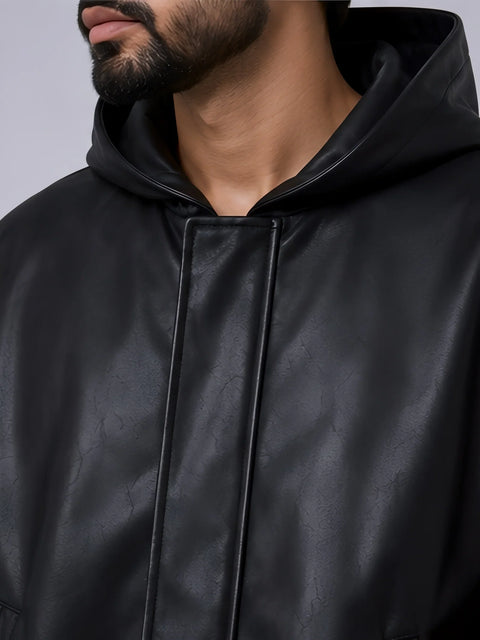 Close-up of a person wearing a black leather jacket with a hood.