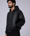 Man wearing a black leather jacket on a gray background